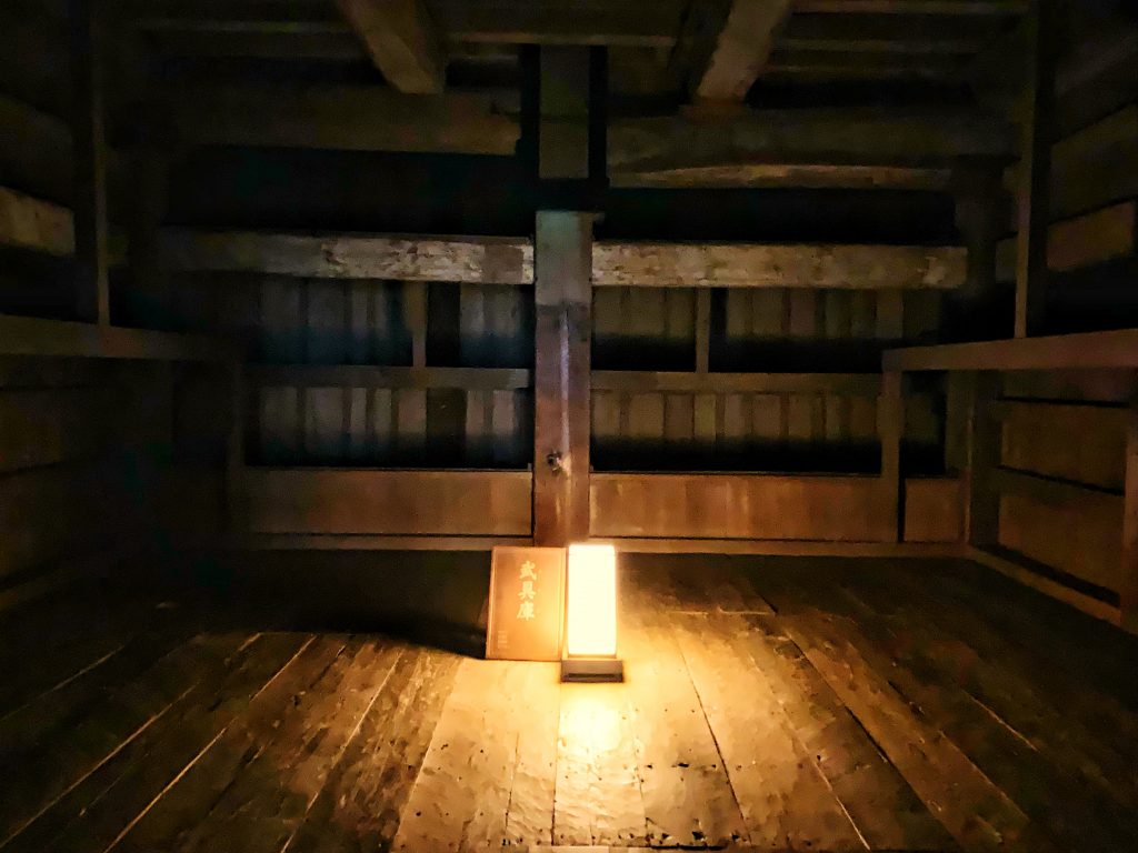 An armoury inside of Osaka Castle lit by a single lantern