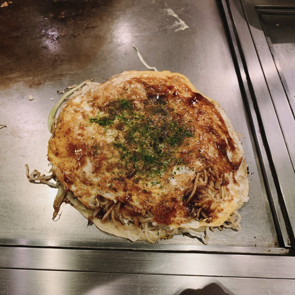 Okonomiyaki served on the furnace it was cooked on