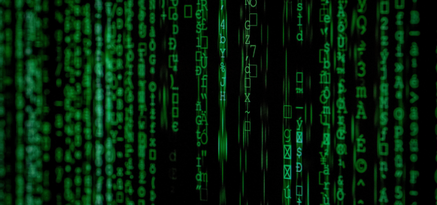 A digital image displaying a matrix of green alphanumeric characters cascading vertically on a black background, reminiscent of digital data streams or the iconic 'Matrix' code rain.